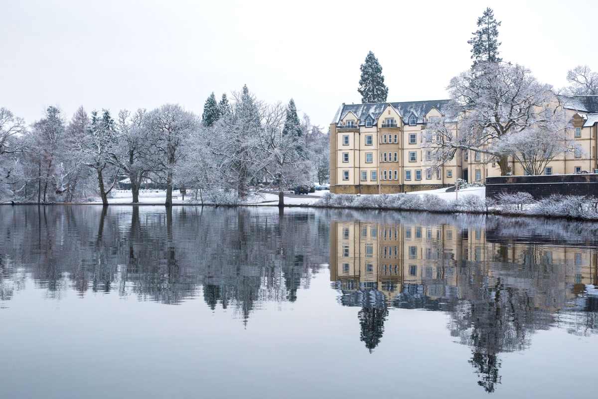 Cameron House surrounded by snow with the loch